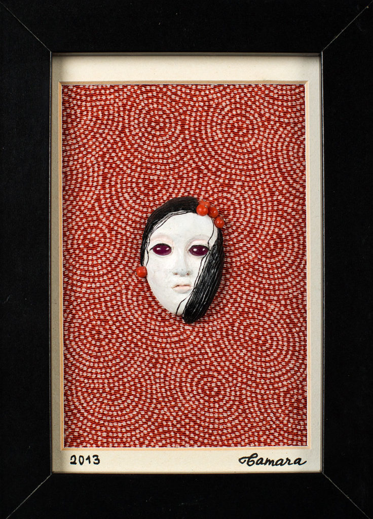 Modelage en polymère, perles de corail et cabochons sur fond de tissu japonais, représentant un masque de femme inspiré des masques japonais de theatre No